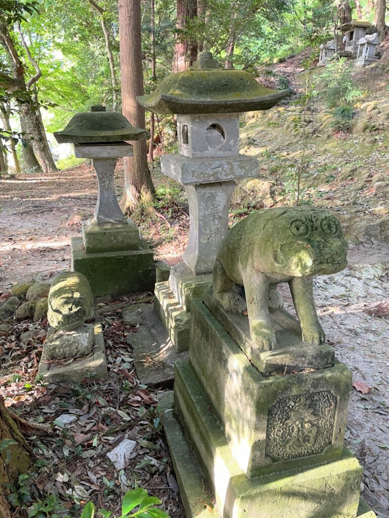 吽形の後ろに置かれた先代狛犬
